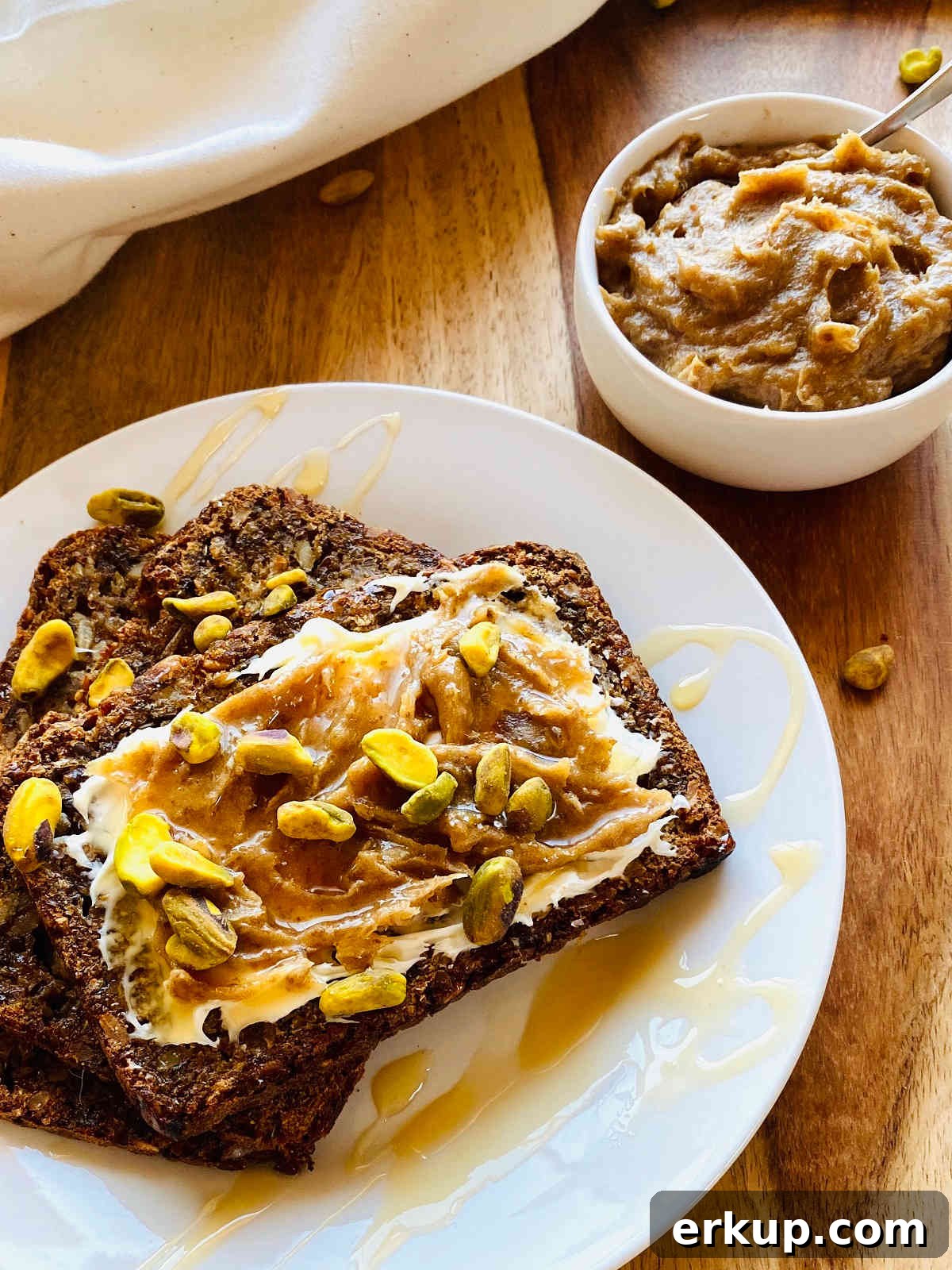 date jam in white dish next to bread smeared with mascarpone, date jam and pistachios