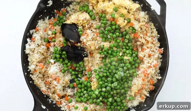 adding oyster sauce and peas to cast iron skillet