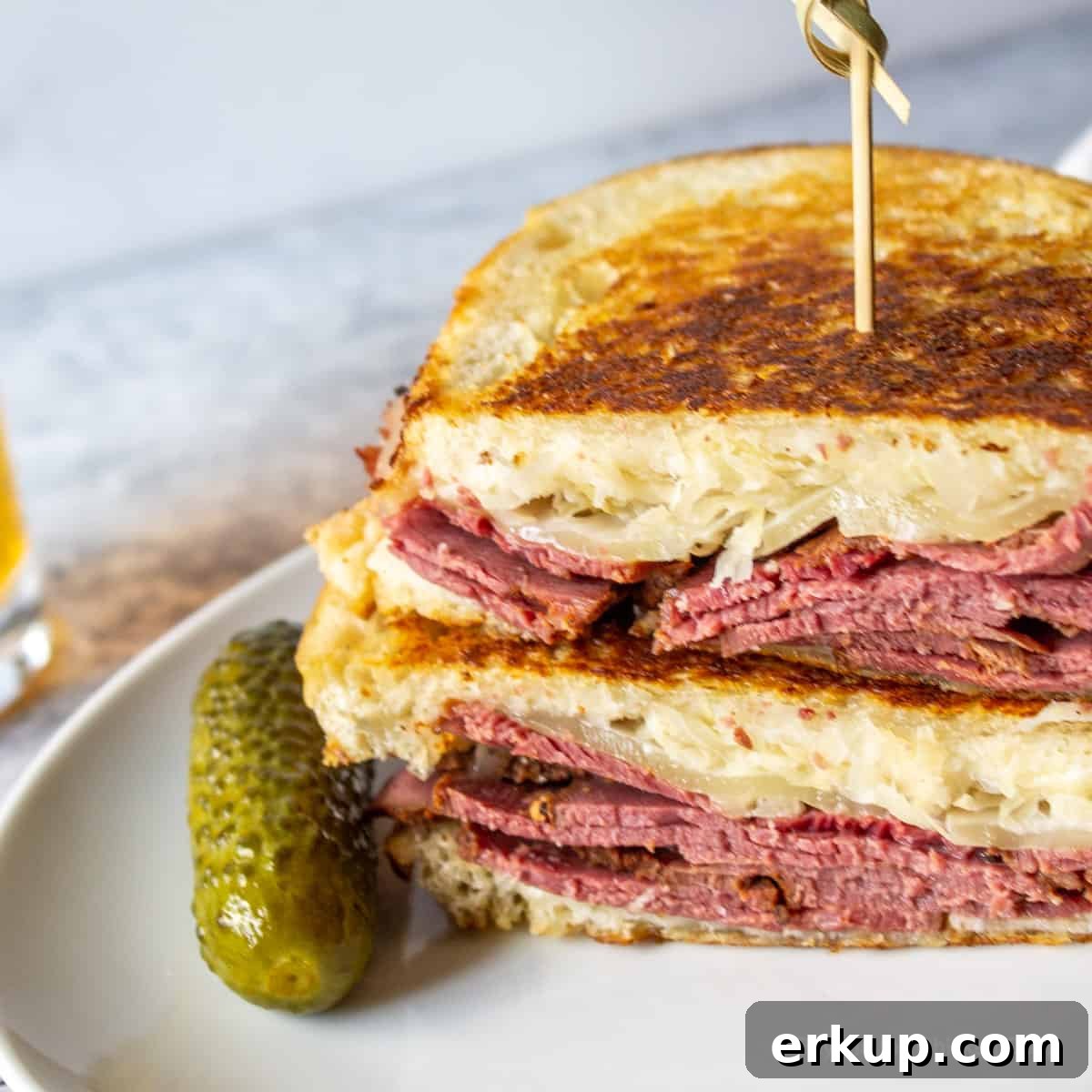 A toasted sandwich with pastrami, sauerkraut and cheese.