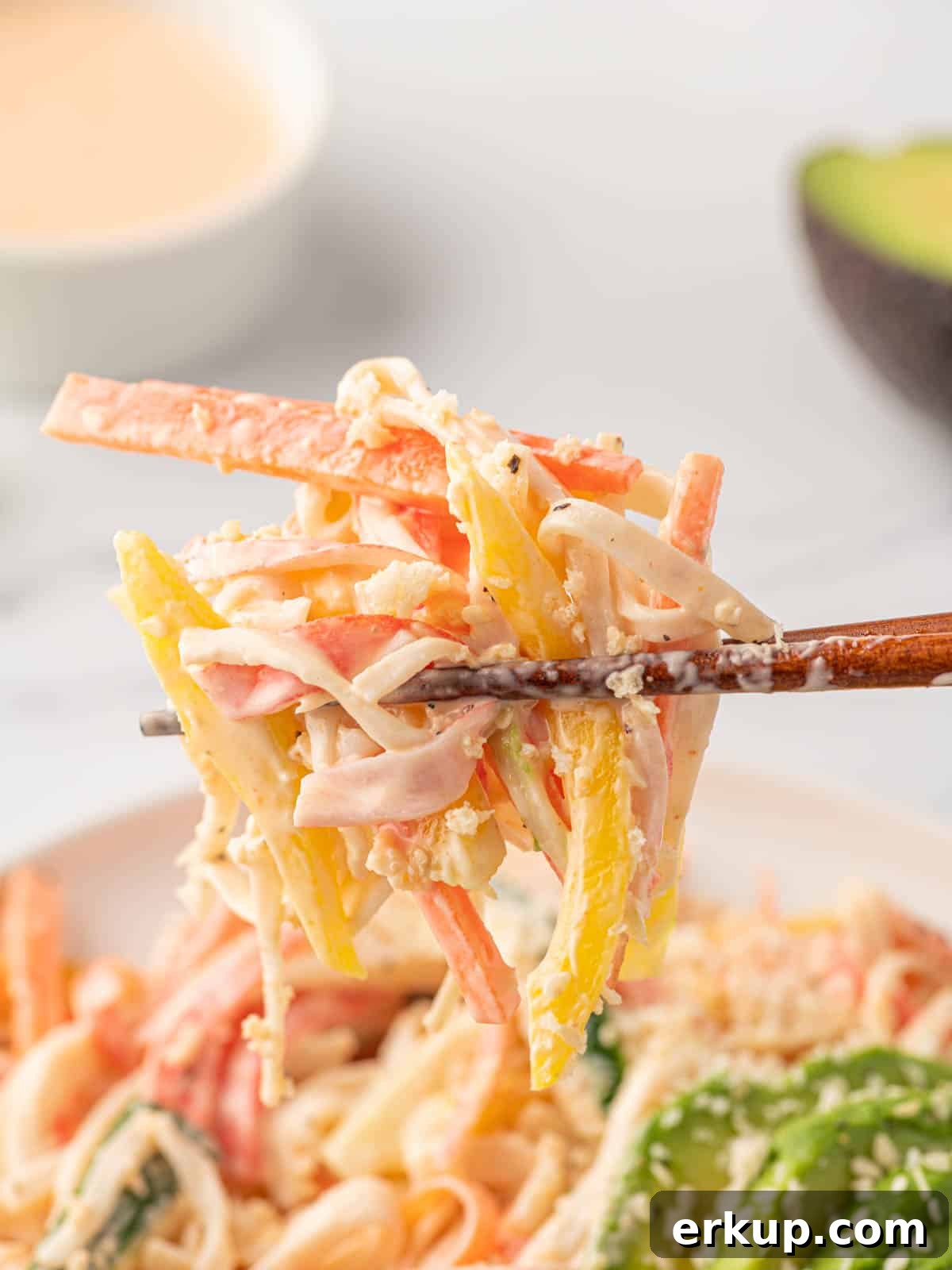 Chopsticks pick up spicy mango kani salad.