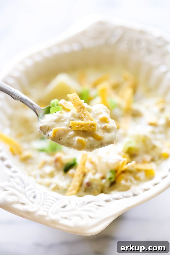 Green Chile Potato Soup in a white bowl with spoon.