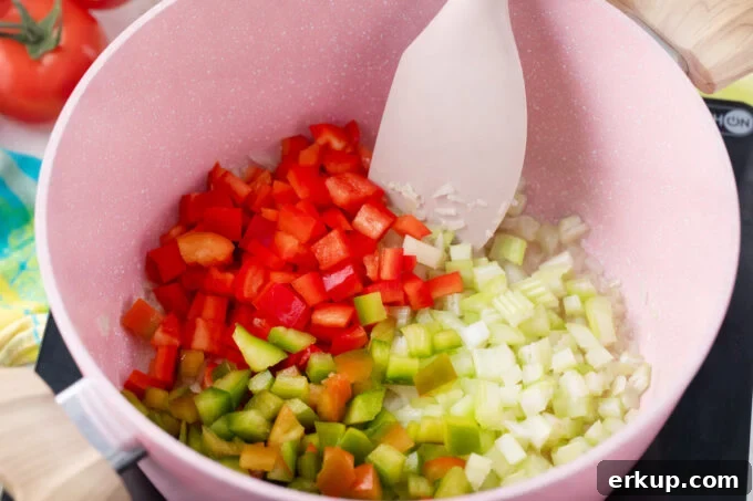 Sautéing bell peppers, onion, garlic, and celery.