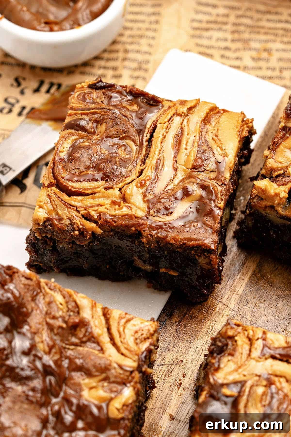 Newspaper sheet and white parchment with swirled brownie squares.