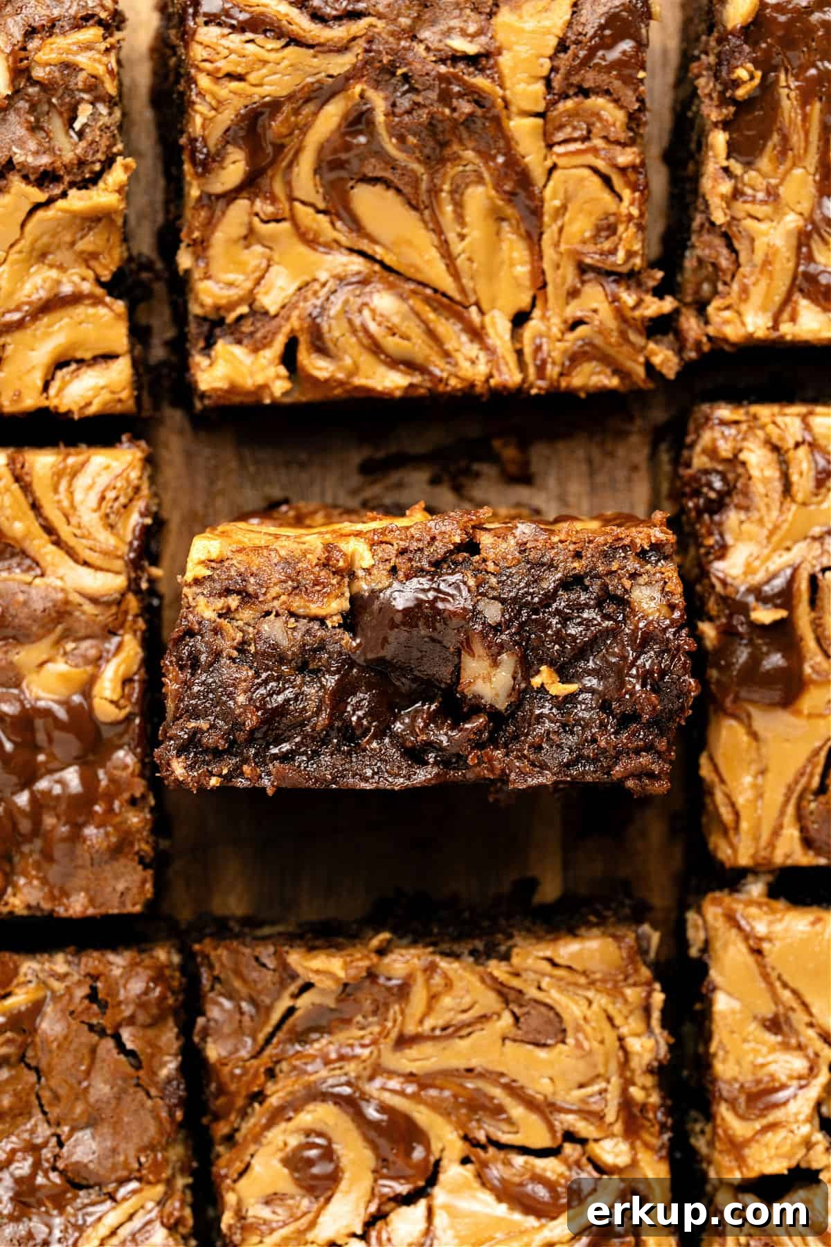 Squares of loaded brownies on a wooden surface. Close up.
