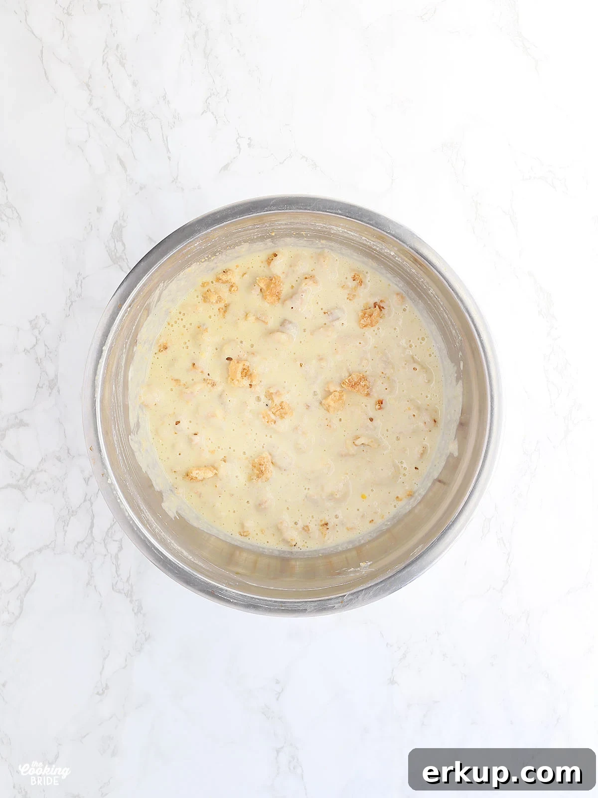 mixed cracklin corn bread batter in a stainless steel mixing bowl