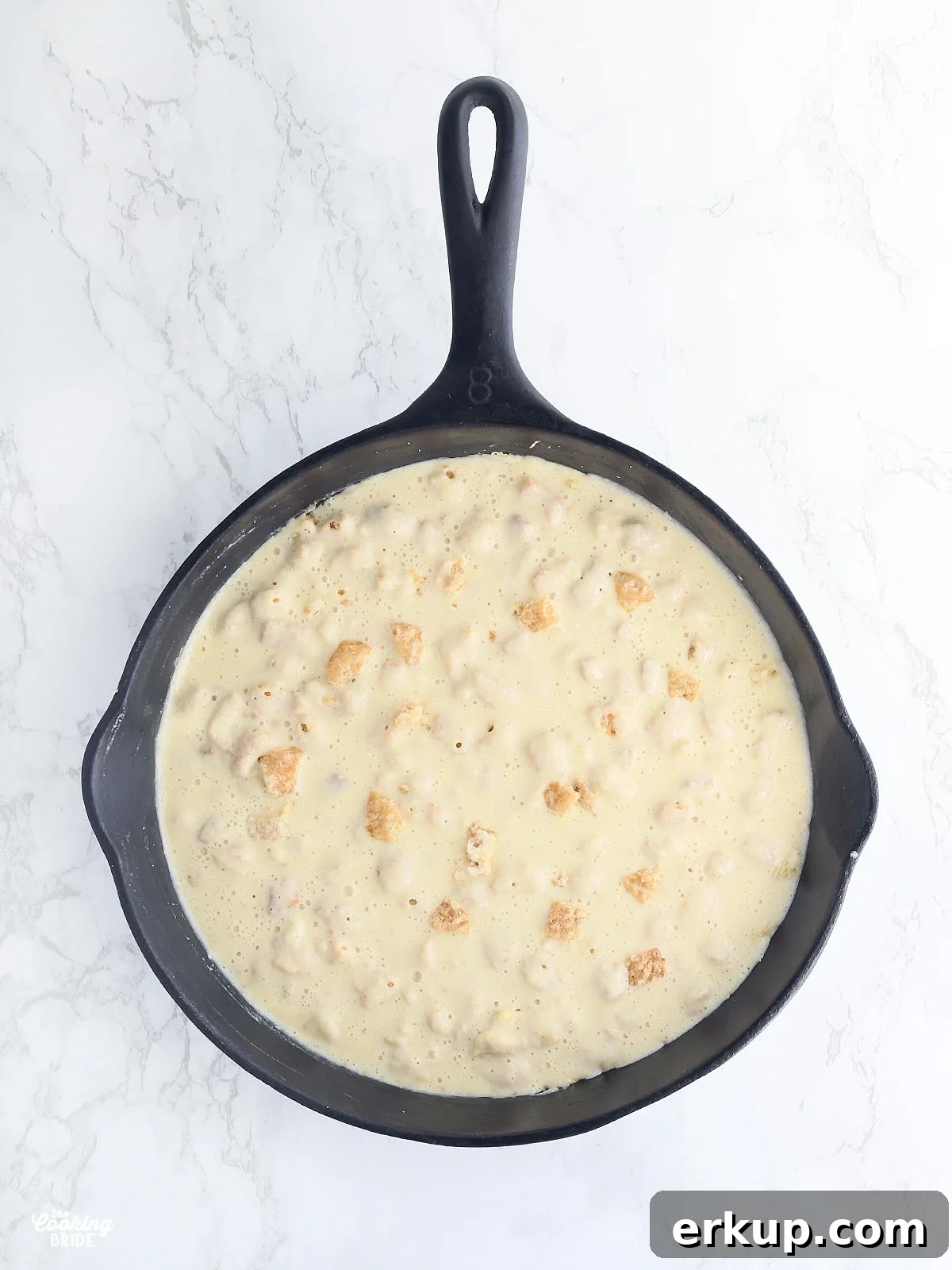 overhead shot of cracklin' corn bread batter in a cast iron skillet
