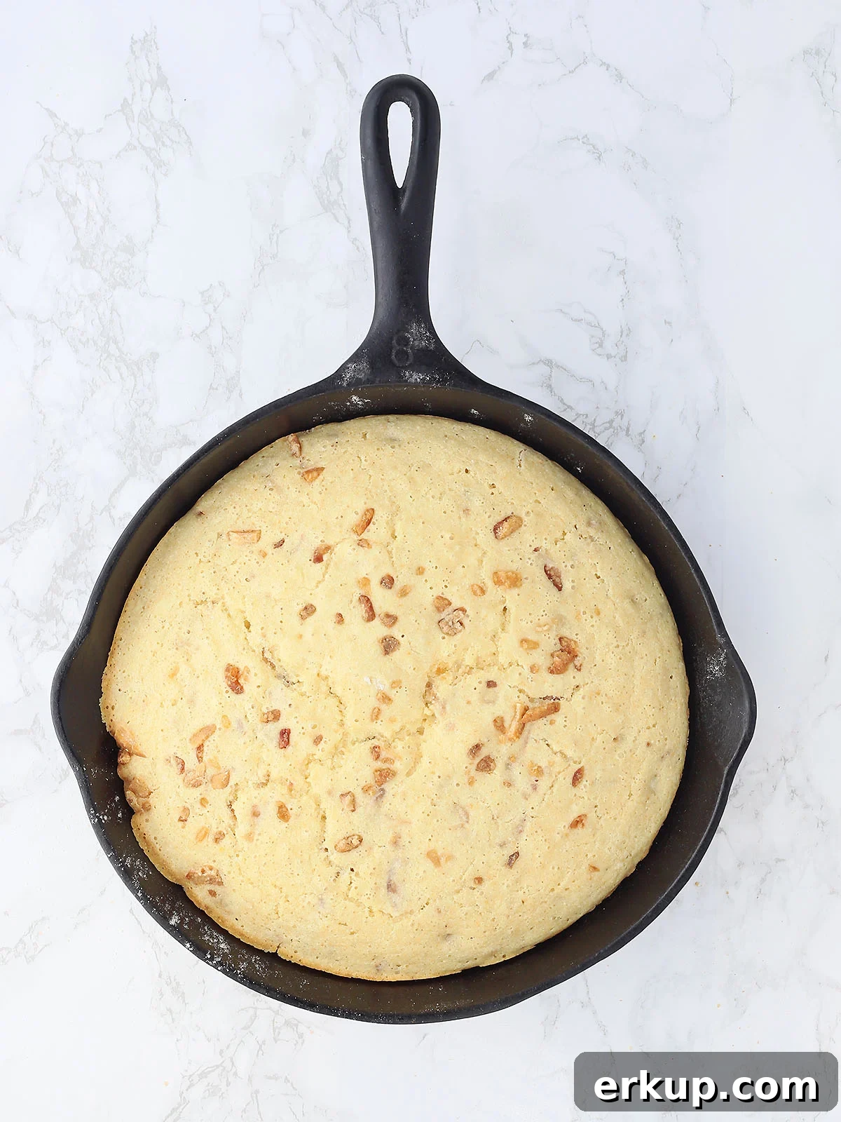 baked cracklin' corn bread in a cast iron skillet after it has come out of the oven