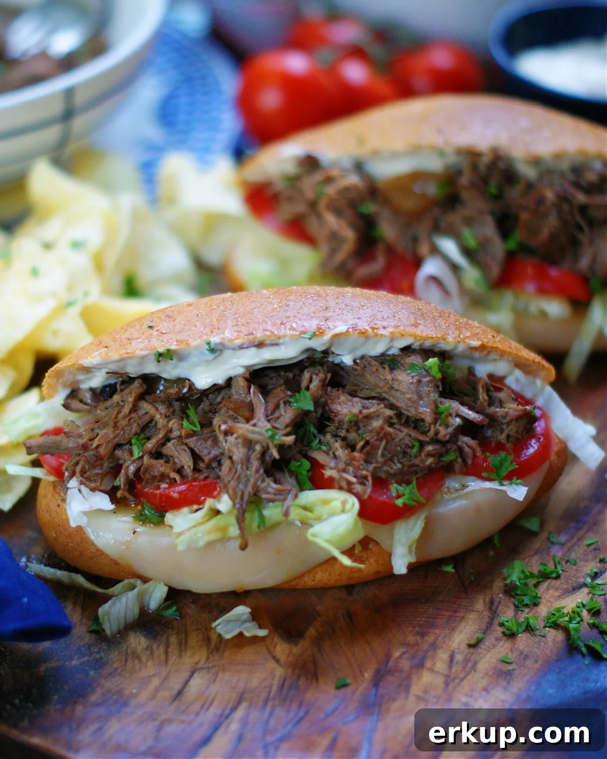 2 roast beef po boy sandwiches served with kettle potato chips.