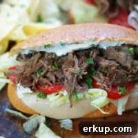 A hot Louisiana Roast Beef Po Boy Sandwich dressed with horseradish, lettuce, tomatoes and Provolone.