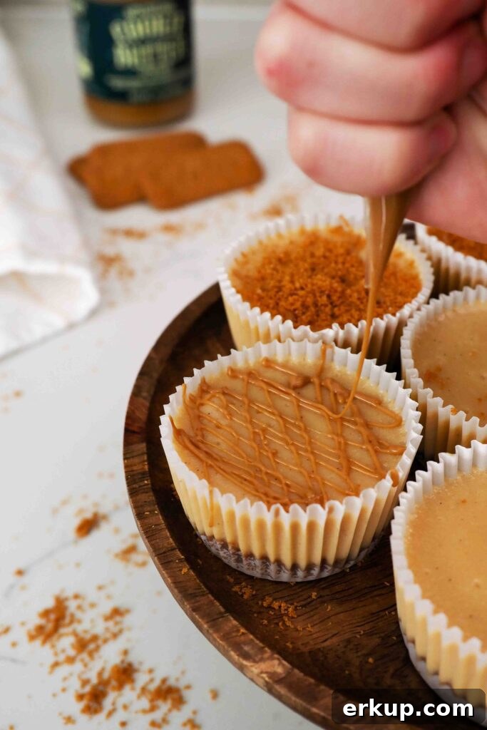 Warm cookie butter is drizzled on top of a mini Biscoff cheesecake.