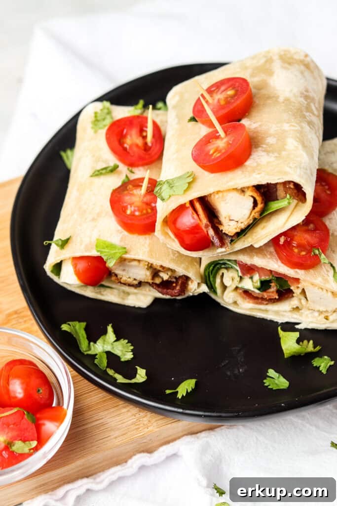 crispy ranch wraps on a black black with tomatoes