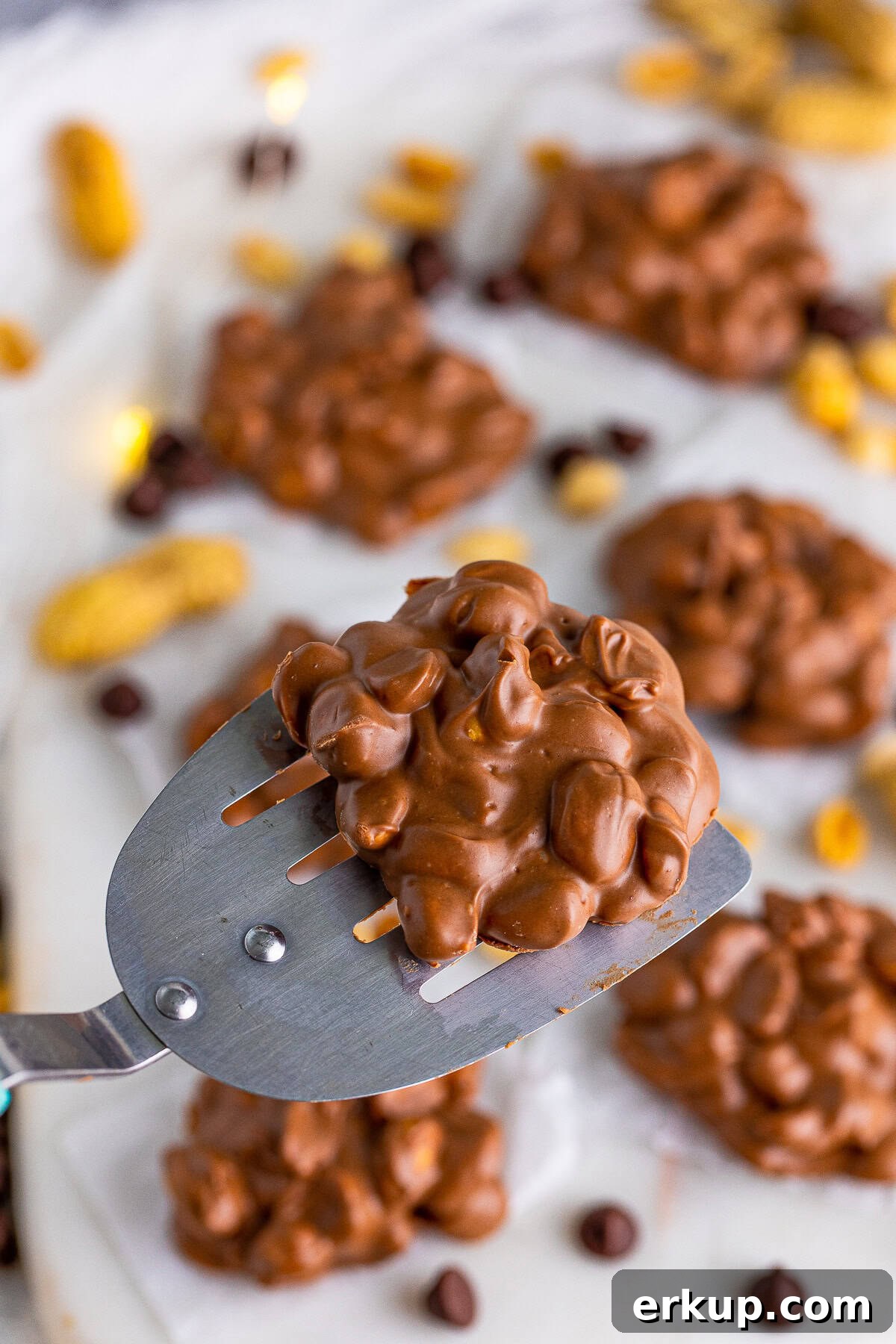Metal spatula holding up one Peanut Cluster.