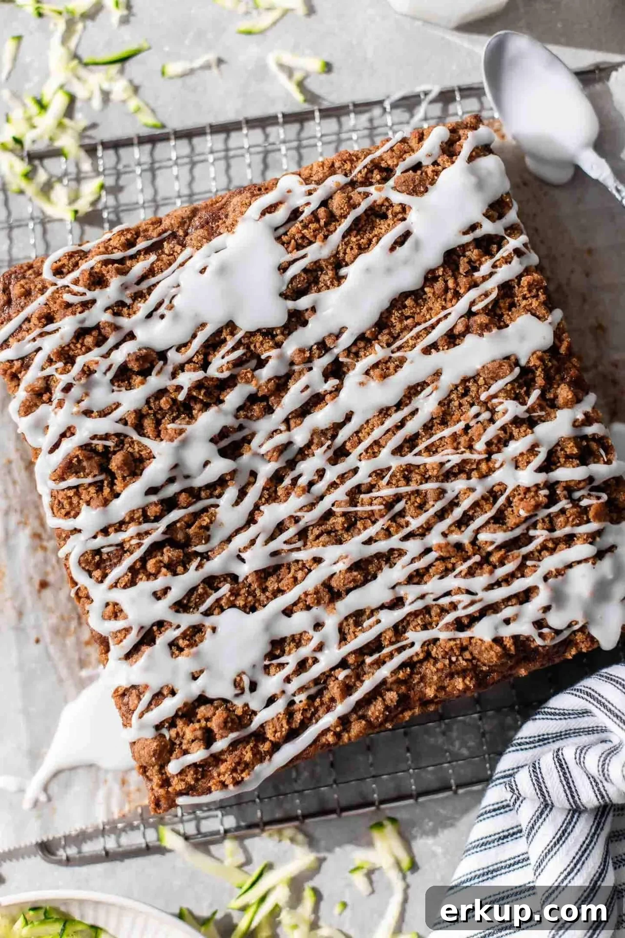 iced sour cream zucchini coffee cake on parchment lined wire rack