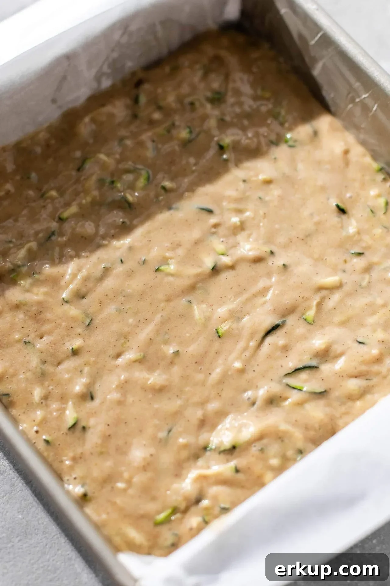 sour cream zucchini coffee cake batter spread into the bottom of a baking pan