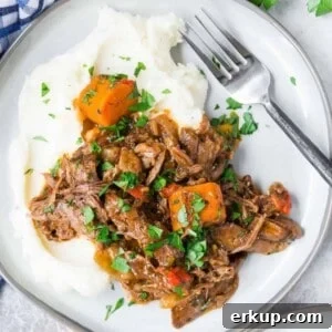 Overhead view of Italian pot roast on a plate, served over mashed potatoes.