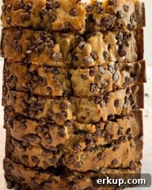 A sliced loaf of chocolate chip banana bread standing vertically on one end.
