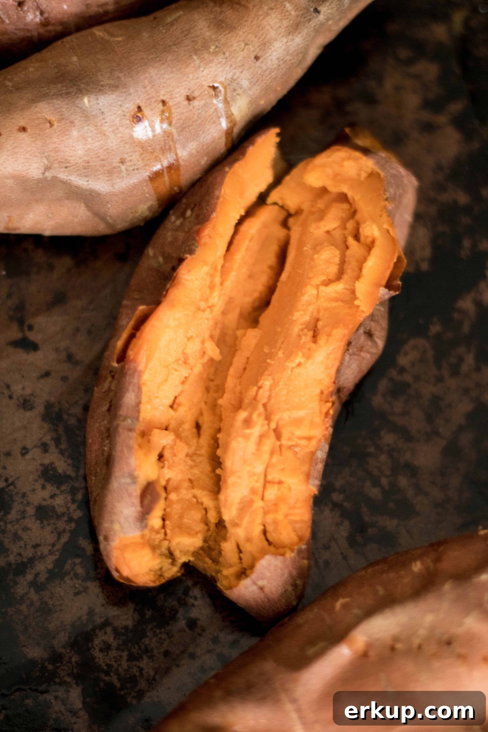 Fall Stuffed Sweet Potatoes with Maple, Pecans and Cranberries 4 Oven baked sweet potato laying on black background
