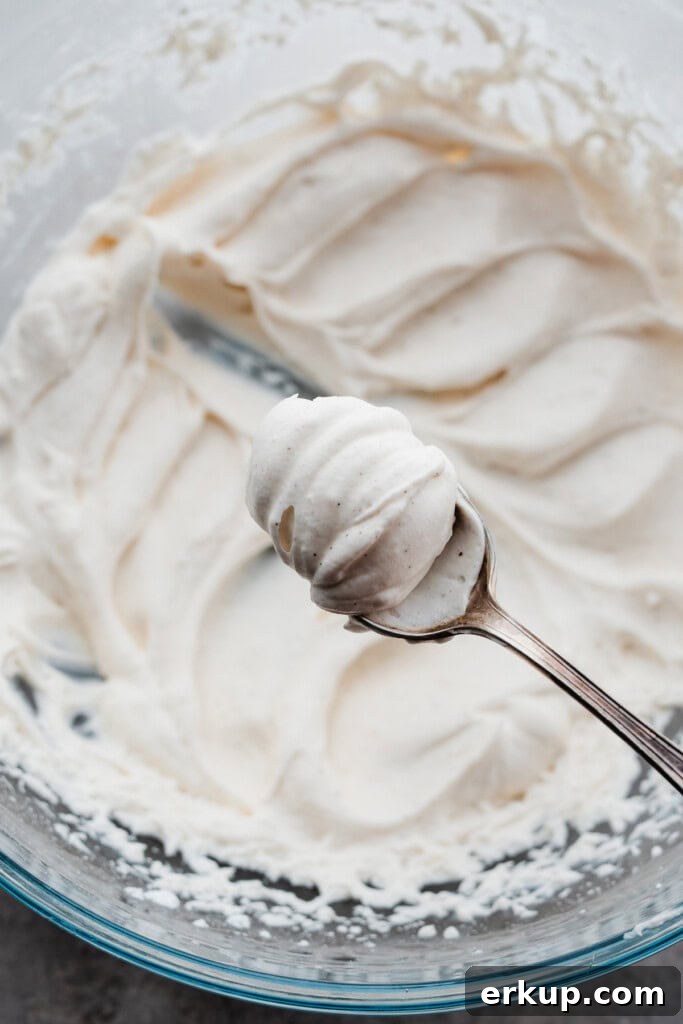A spoon holding the dollop of whipped cream.