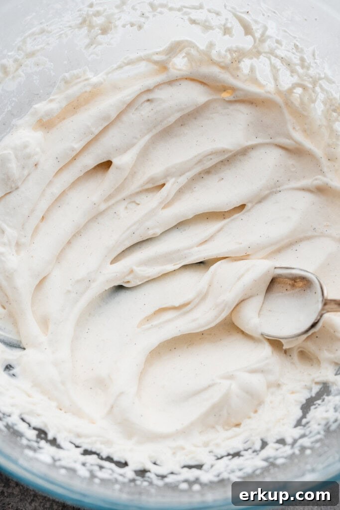 A spoon making swoops in the bowl of whipped cream.