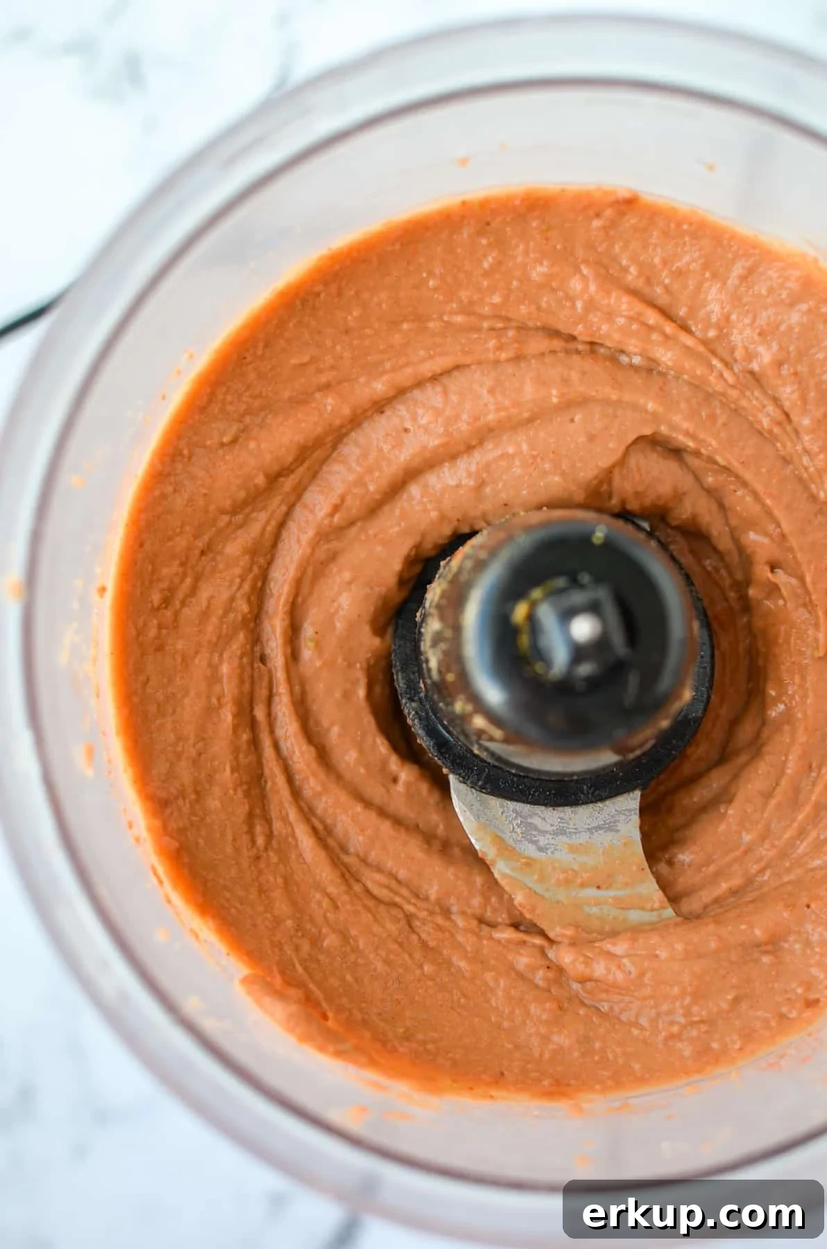 A food processor with blended bean dip.