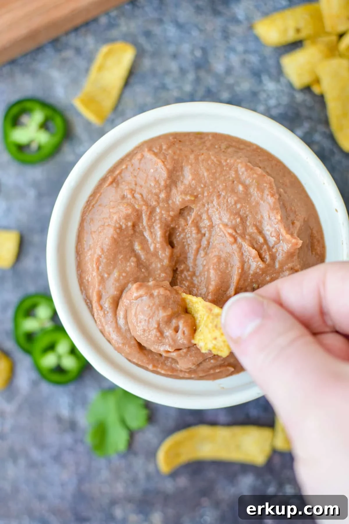 Dipping a corn chip into bean dip.