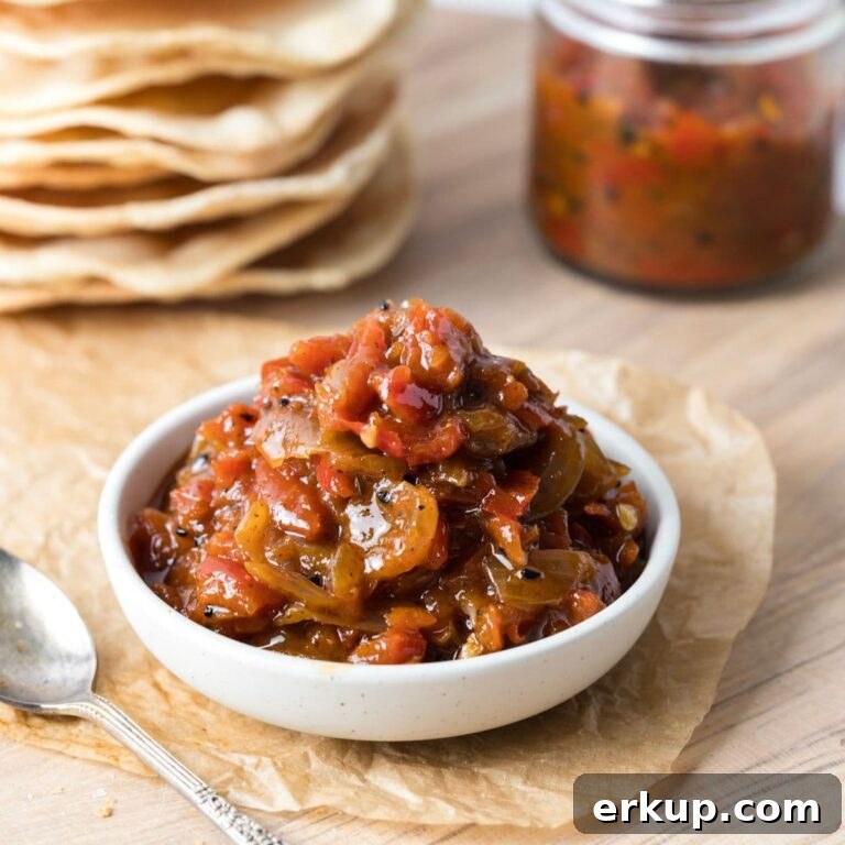 A bowl of red pepper relish sitting in front of sourdough crackers.