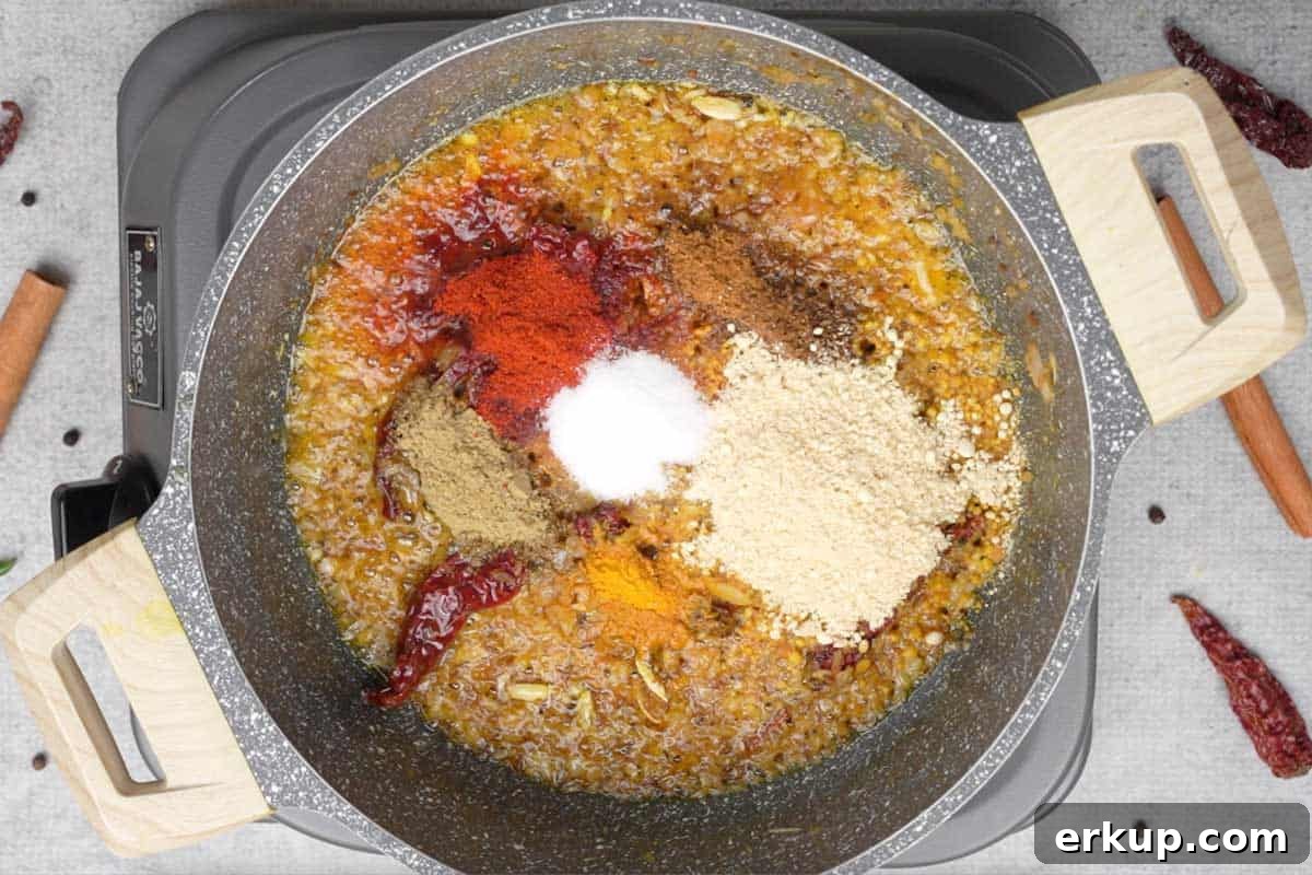 Spice powders and besan added to the pan.