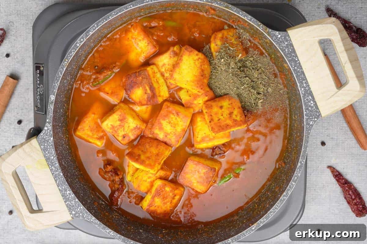 Water, fried paneer and kasuri methi added to the pan.