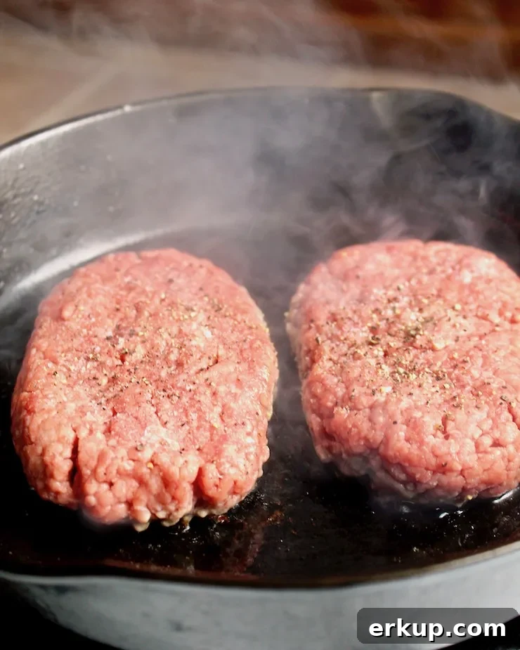 Diner-Style Patty Melts, two beef patties cooking in skillet