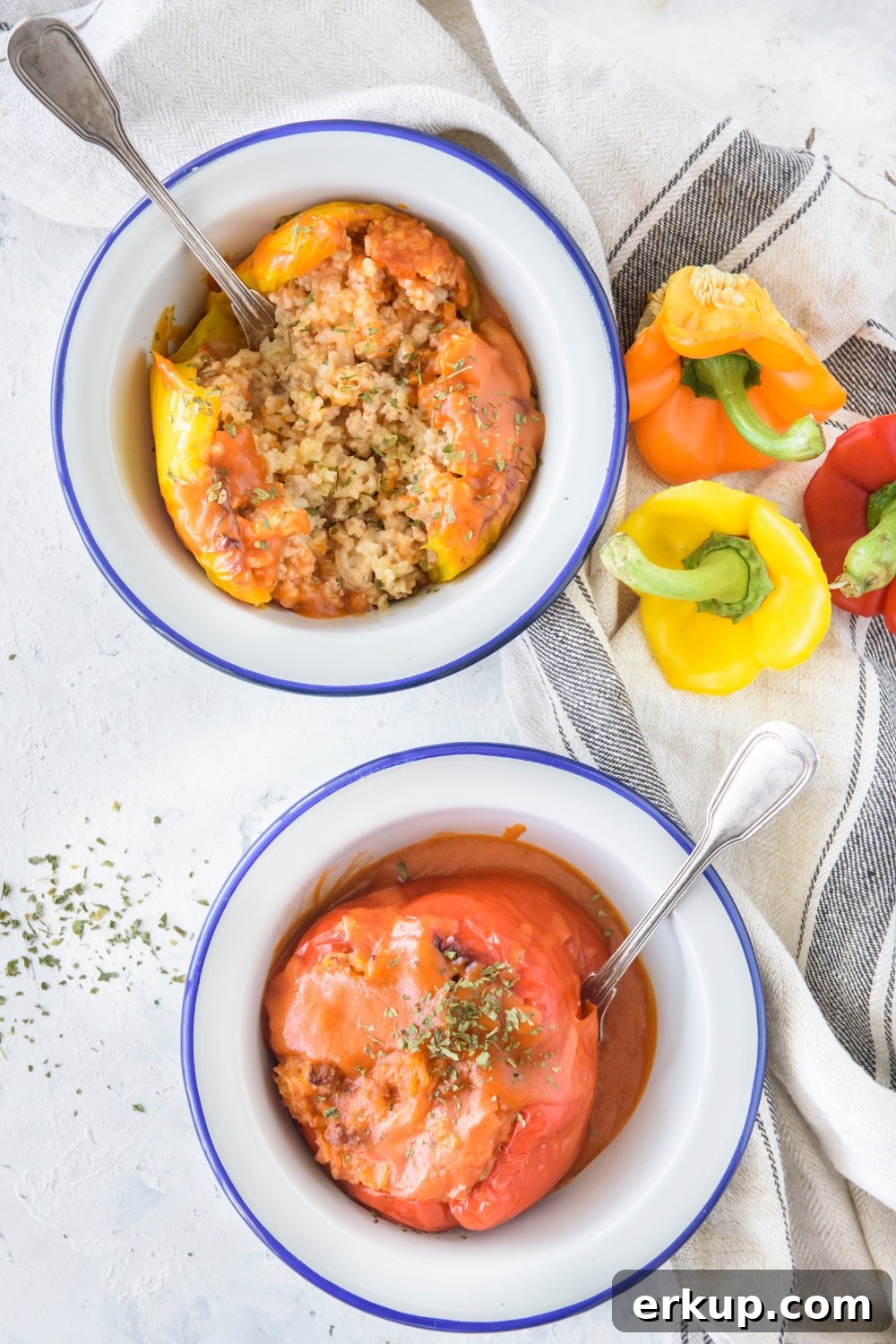 Old-Fashioned Stuffed Bell Peppers Recipe 2 Two bowls of stuffed bell peppers covered stuffed with rice and ground meat and covered in tomato sauce.