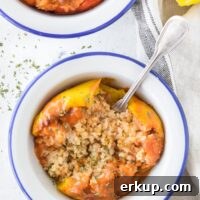 A bowl with a yellow bell pepper stuffed with rice and ground meat and topped with seasonings.