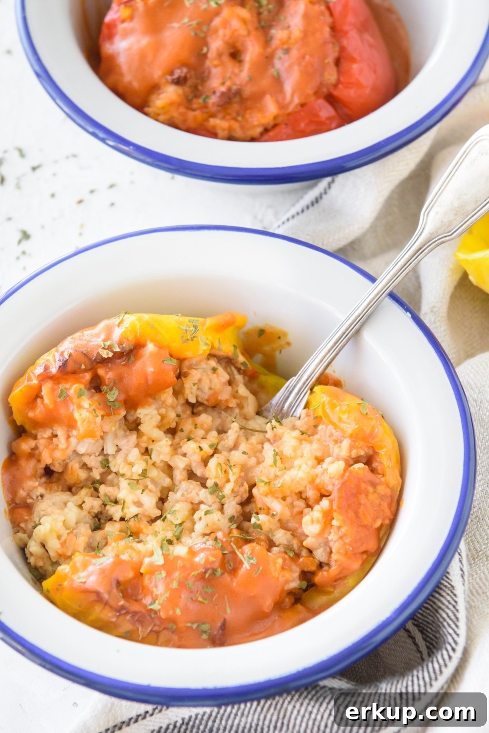 Old-Fashioned Stuffed Bell Peppers Recipe 3 A bowl with a yellow bell pepper stuffed with rice and ground meat and topped with seasonings.