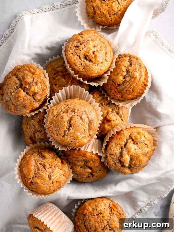 Overhead view of a bunch of banana carrot muffins on a beige napkin.