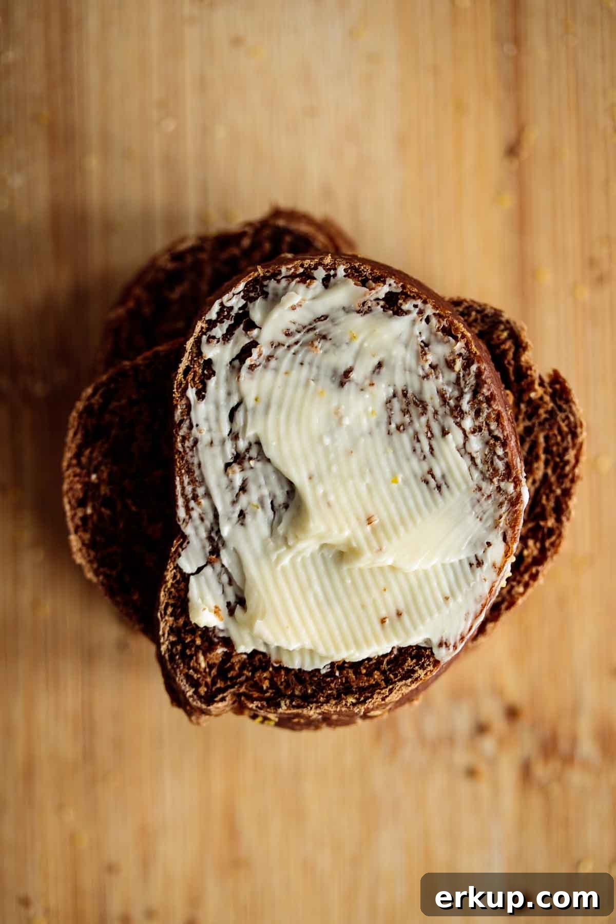 Bread slice with a spread of vegan butter, showing part of its brown crumb.