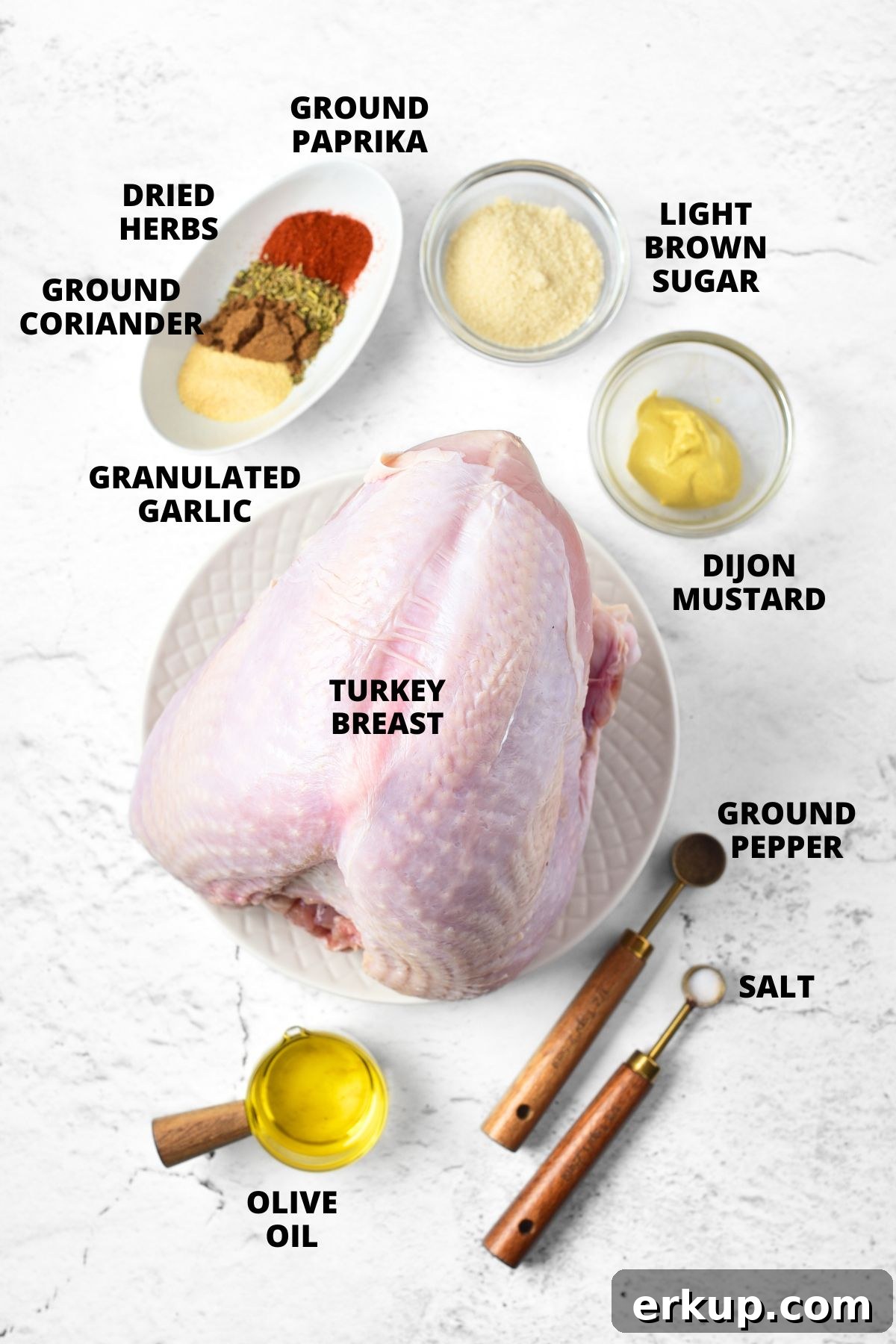 Top down view of ingredients required for roasted turkey breast recipe laid out on marble board.