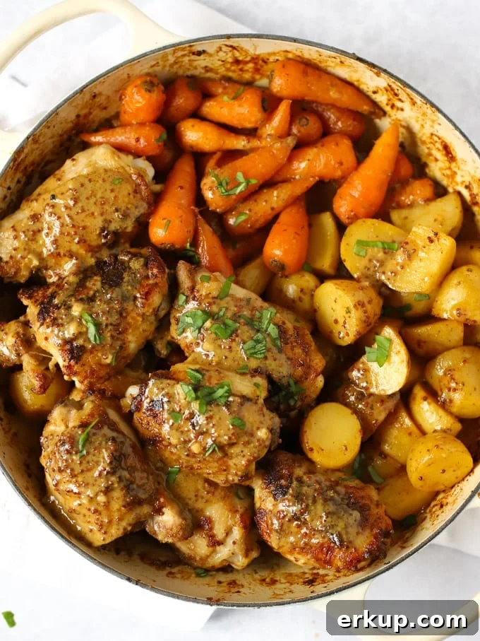 Chicken thighs with honey and mustard sauce with potatoes and carrots.
