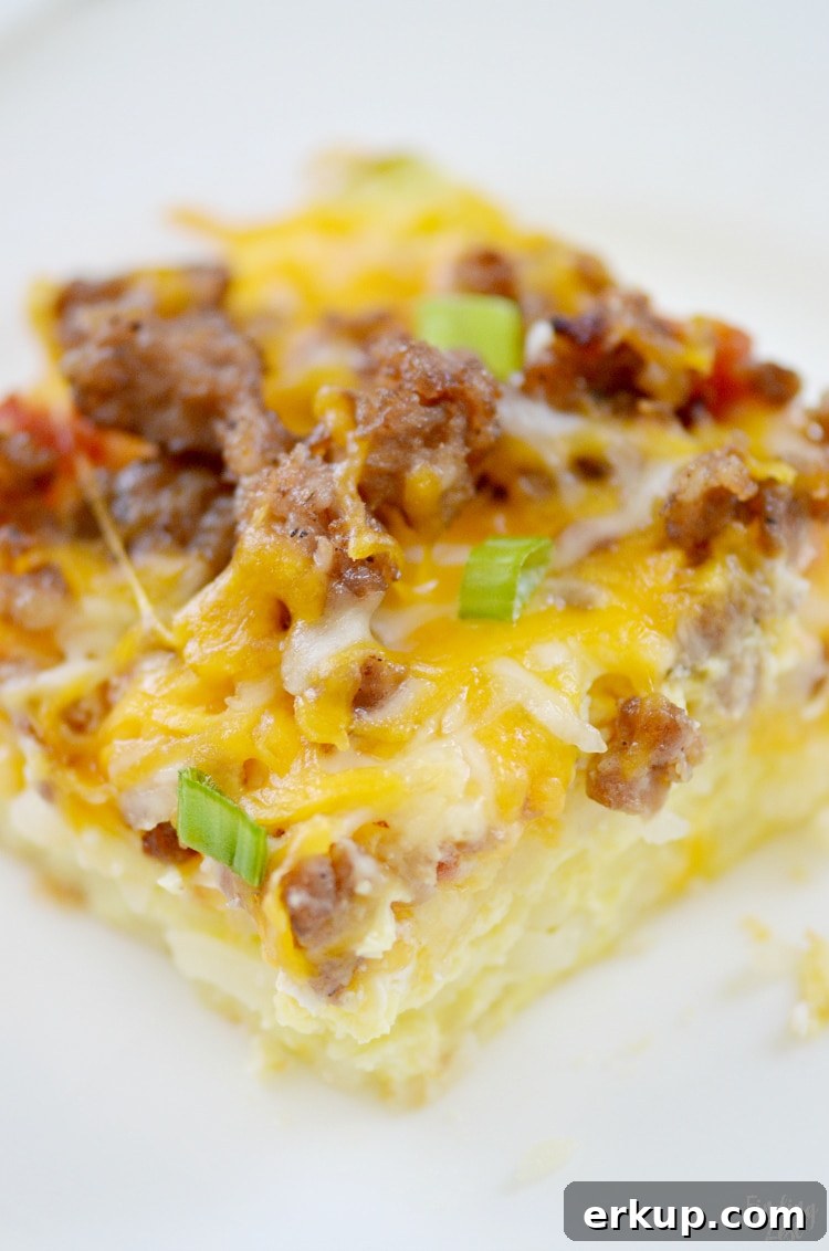 Cut hash brown casserole topped with egg, sausage, cheese and Rotel