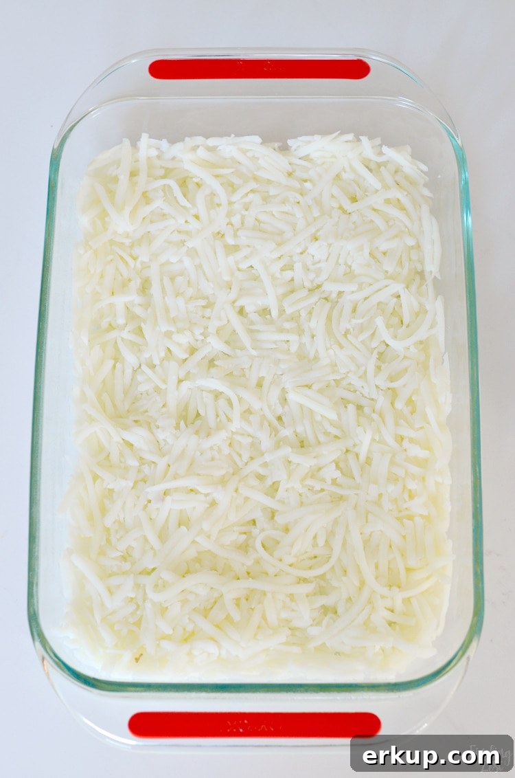 Layering fresh hash browns in baking dish