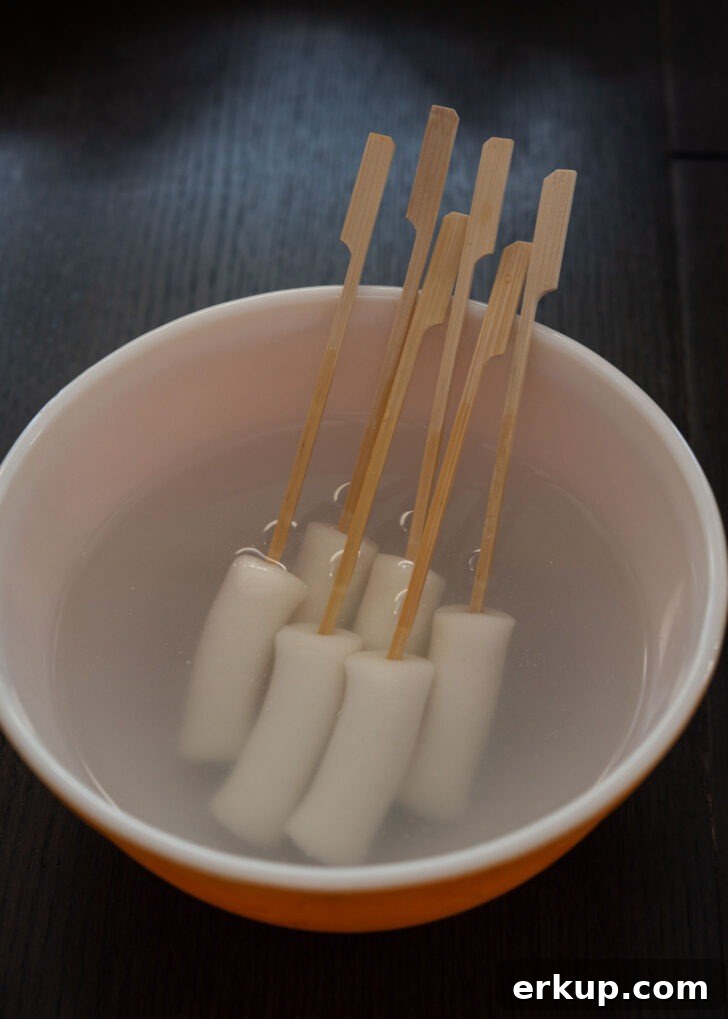 Softened rice cake logs threaded onto wooden skewers