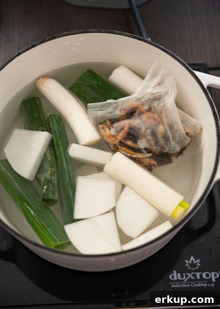 Ingredients for Korean fish cake soup broth simmering in a pot
