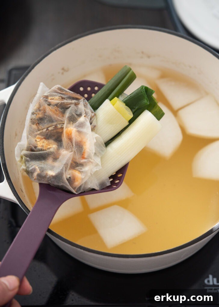 Removing the dashi packet from simmered soup broth to keep the flavor clean and clear.