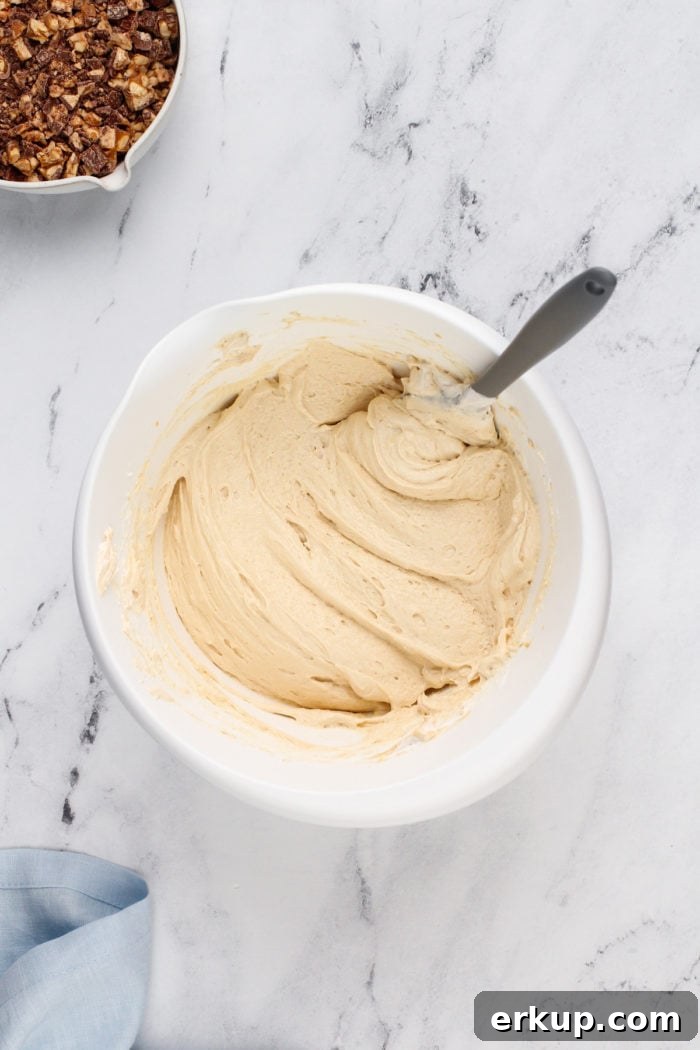 Snickers dip base in a white bowl, waiting for chopped snickers bars to be added.