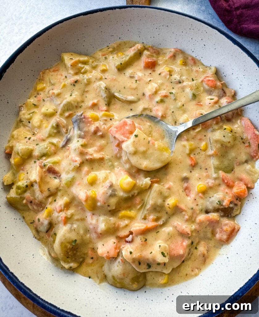creamy salmon chowder with corn and potatoes in a white bowl with a spoon
