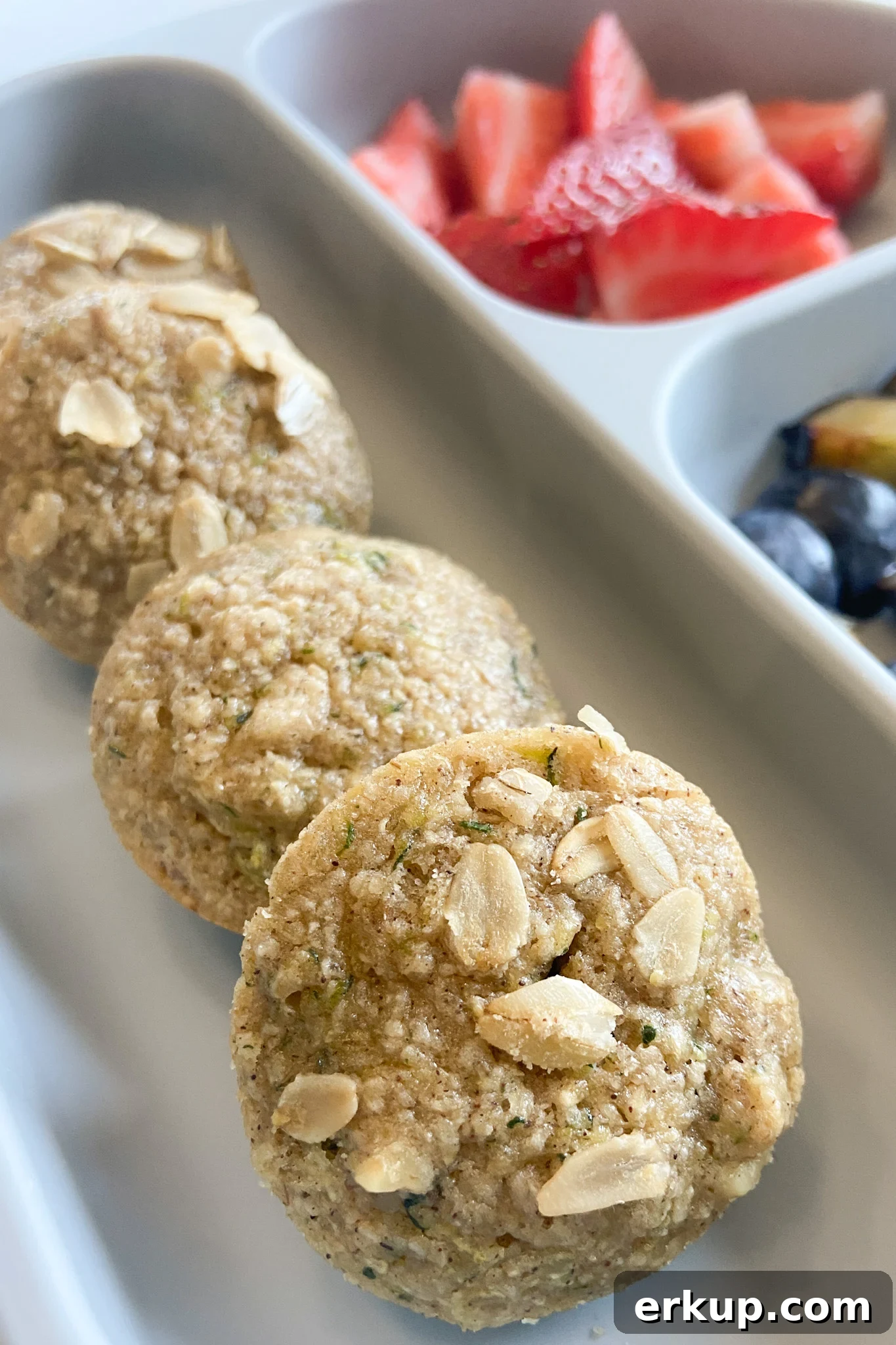 Zucchini muffins served with fruits.