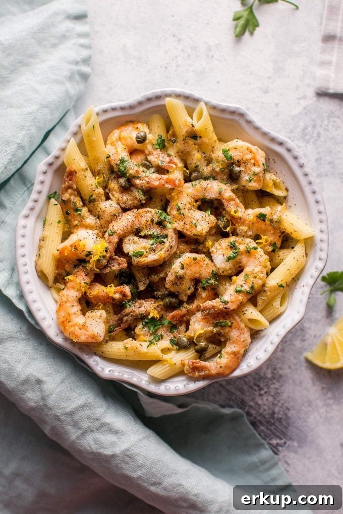 30-Minute Shrimp Piccata with Lemon Caper Sauce 4 white bowl with easy shrimp piccata served over penne beside cloth napkin and lemon slice