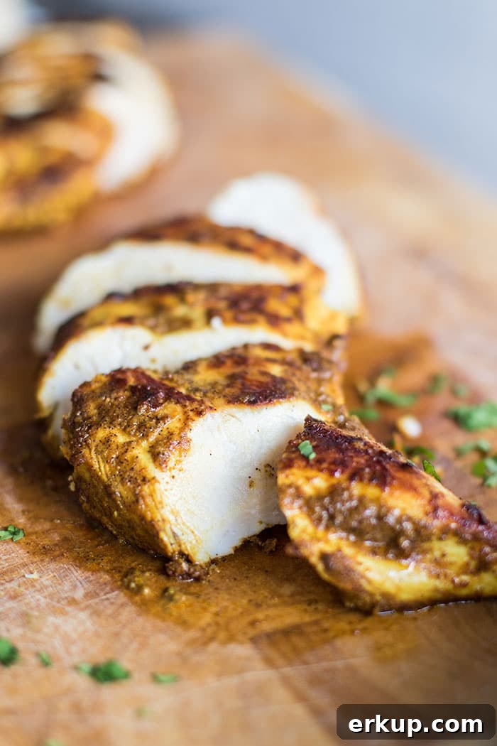 A cutting board with sliced moroccan spiced chicken breasts.