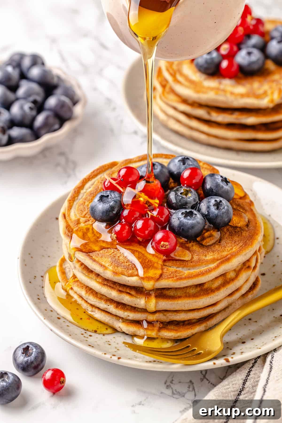 Pouring maple syrup over protein pancakes