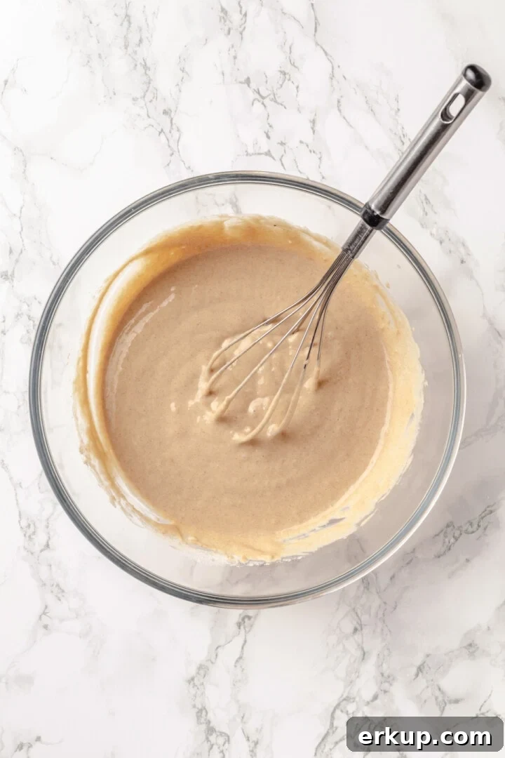 Overhead view of batter for protein pancakes in mixing bowl with whisk