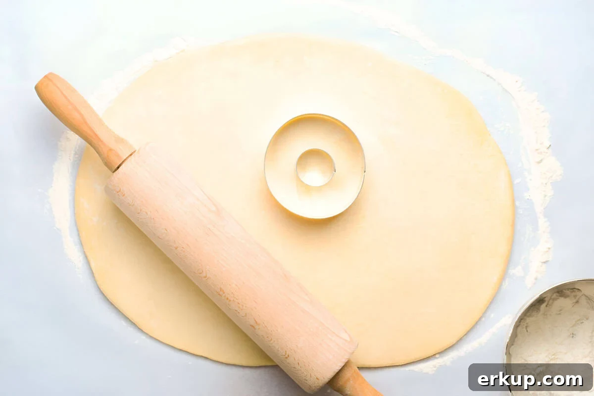 Cinnamon Sugar Donuts Recipe From Scratch 10 cinnamon sugar donut dough ready to be cut out with a circle cutter and a rolling pin.