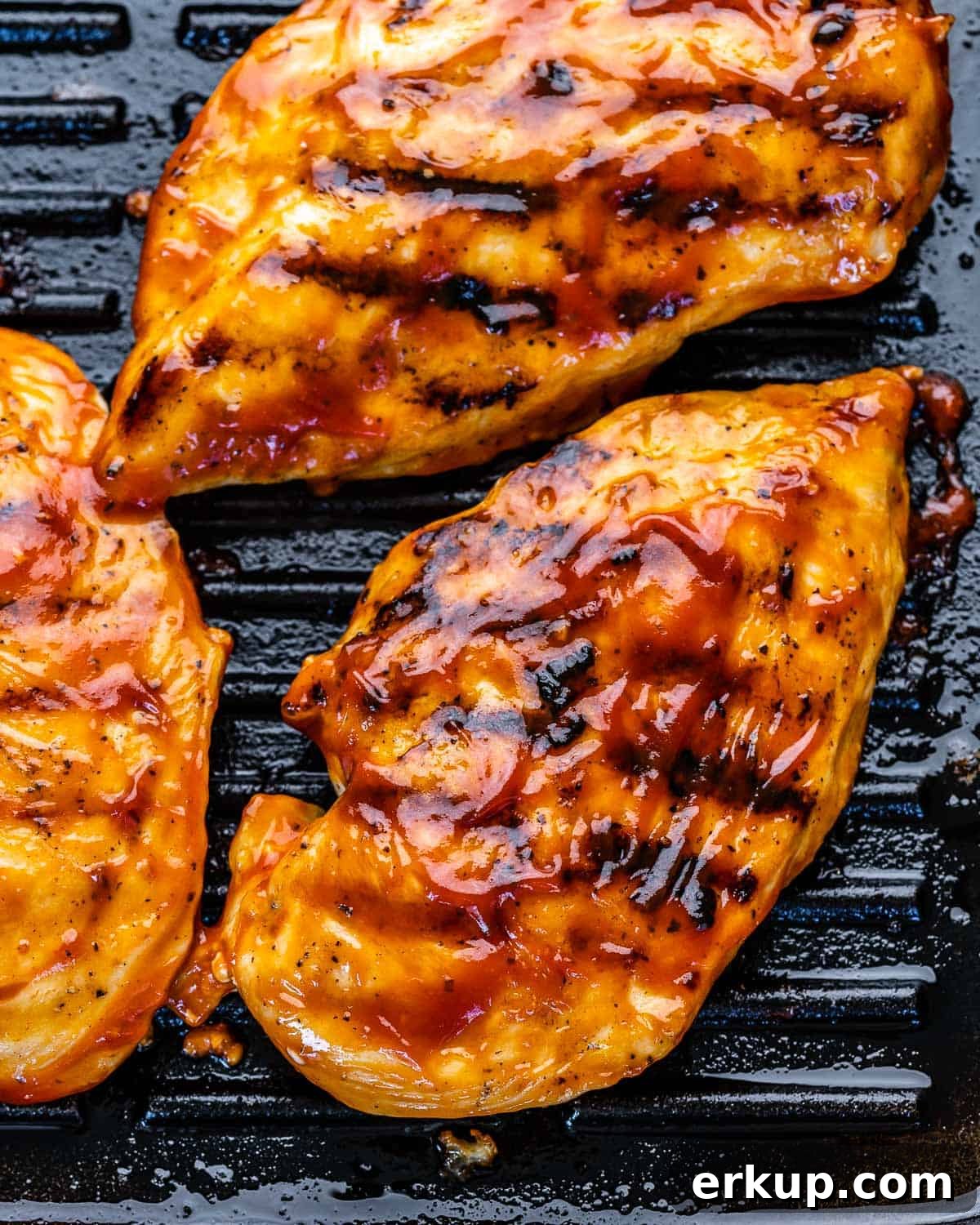 top view of chicken breasts on grill pan with BBQ sauce